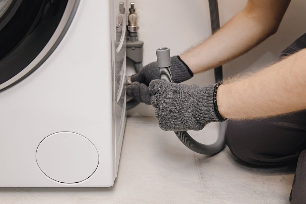 Plumber repairing washing machine
